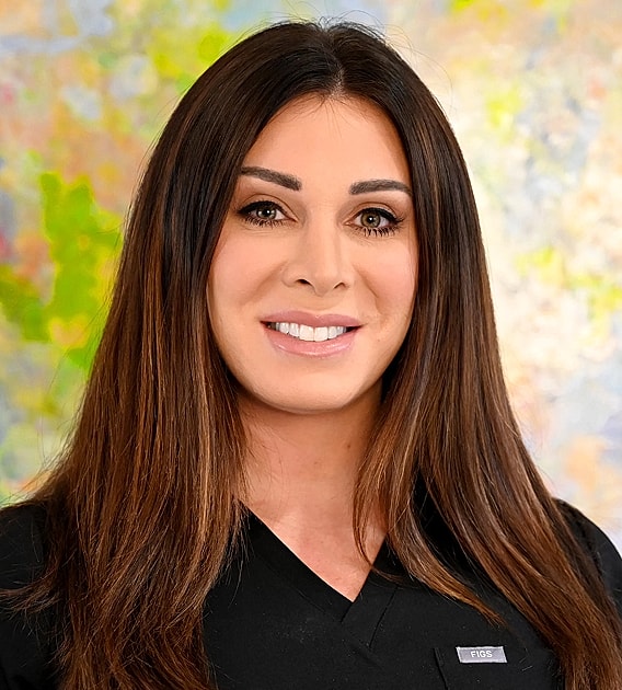 Smiling woman in professional attire with artwork background.