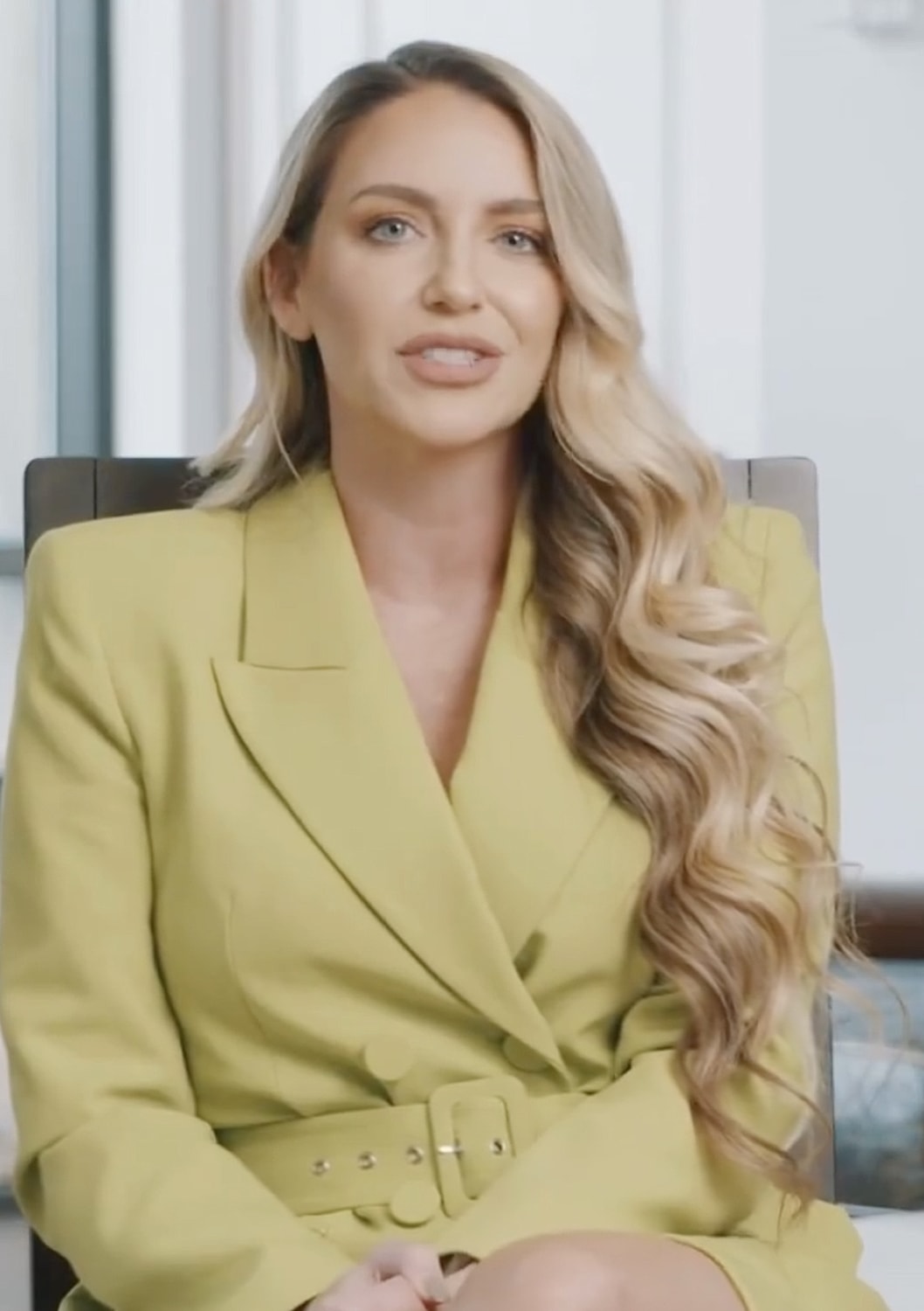 Woman speaking in a stylish outfit video interview.