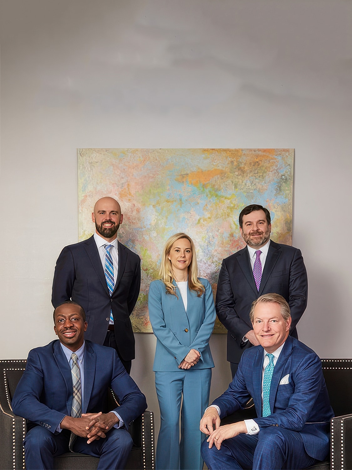 Woman in a sleek black dress leaning elegantly.